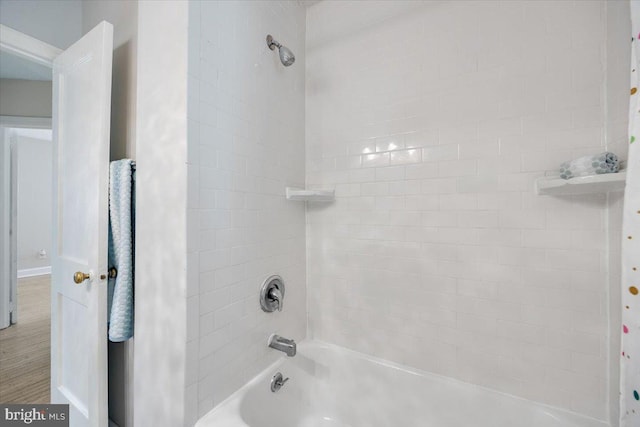 bathroom featuring wood finished floors and shower / tub combo with curtain