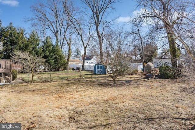 view of yard featuring an outdoor structure, a storage shed, and fence