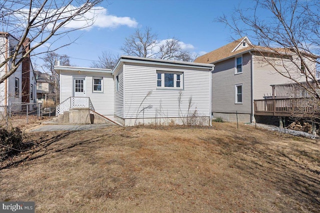 rear view of house with a deck and a yard