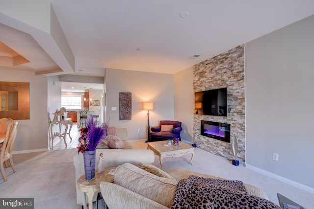 living room featuring a stone fireplace, carpet, visible vents, and baseboards