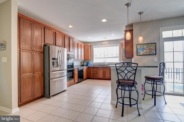 kitchen featuring a breakfast bar area, decorative light fixtures, a peninsula, stainless steel refrigerator with ice dispenser, and a sink