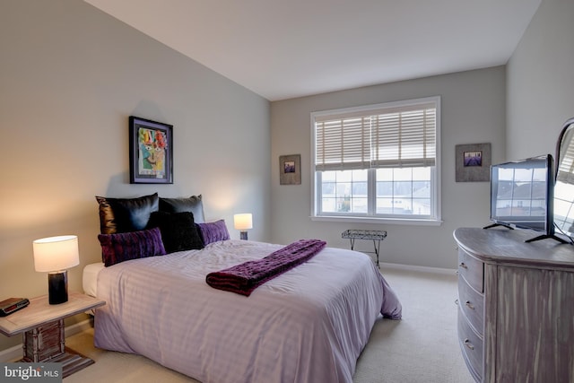 bedroom featuring light colored carpet and baseboards