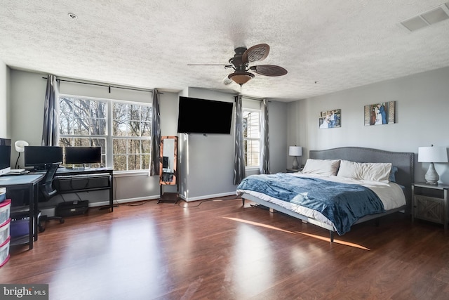 bedroom featuring ceiling fan, dark wood-style flooring, visible vents, and baseboards