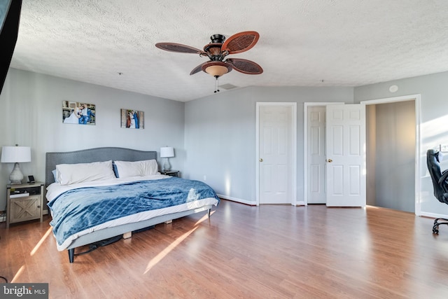 bedroom featuring a textured ceiling, ceiling fan, and wood finished floors