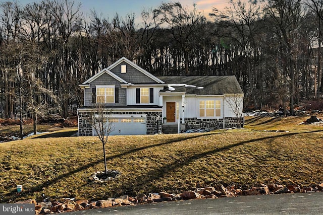 view of front of home featuring an attached garage, stone siding, and a front yard