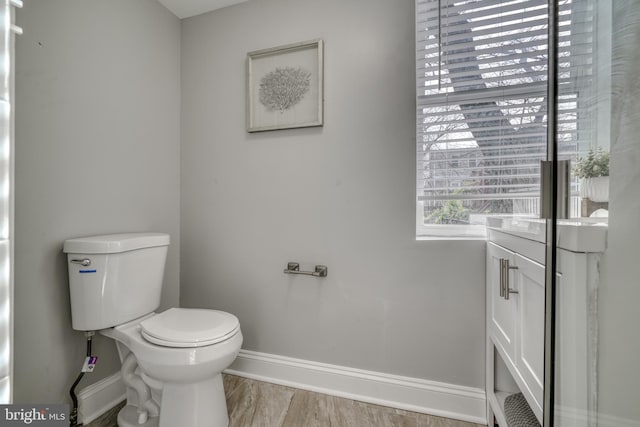 bathroom featuring toilet, baseboards, and wood finished floors