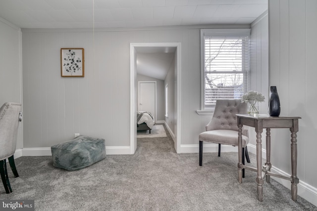 living area with baseboards and light colored carpet