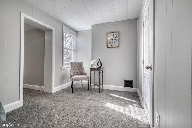 sitting room featuring baseboards, visible vents, and dark carpet