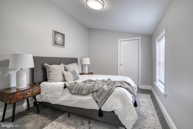 bedroom featuring lofted ceiling, baseboards, and carpet floors