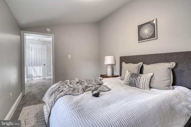 carpeted bedroom with lofted ceiling and baseboards