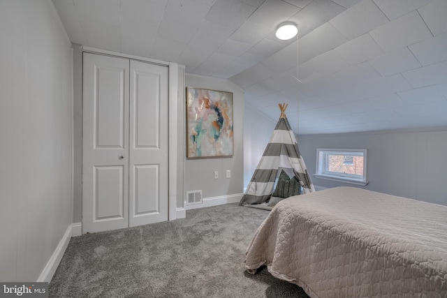 carpeted bedroom featuring baseboards, visible vents, vaulted ceiling, and a closet