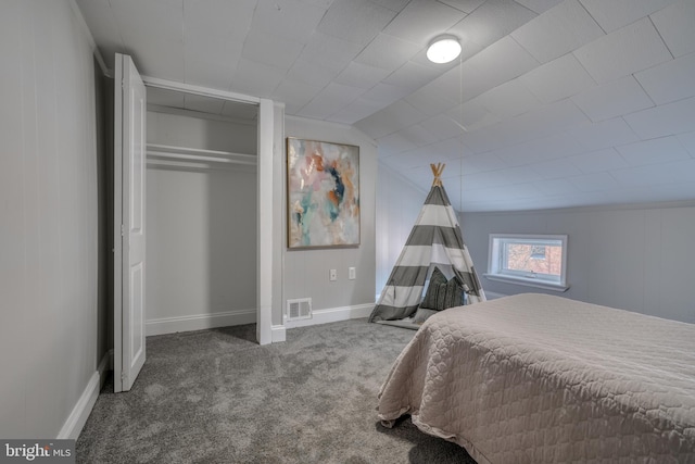 carpeted bedroom with lofted ceiling, a closet, visible vents, and baseboards