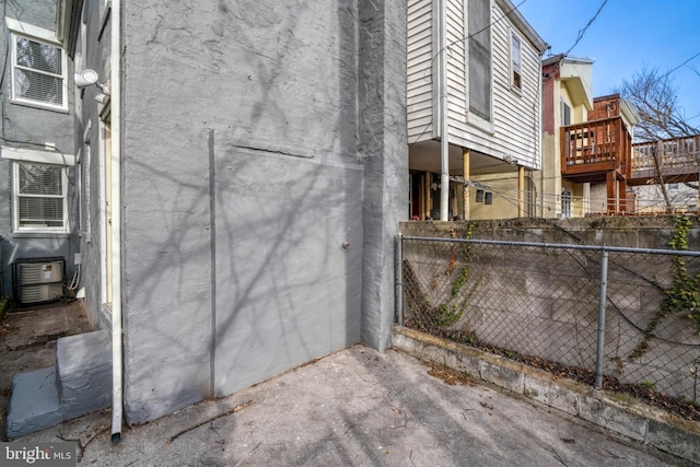 view of side of home featuring fence and stucco siding