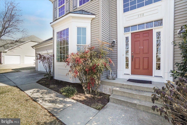 view of exterior entry featuring a garage and concrete driveway