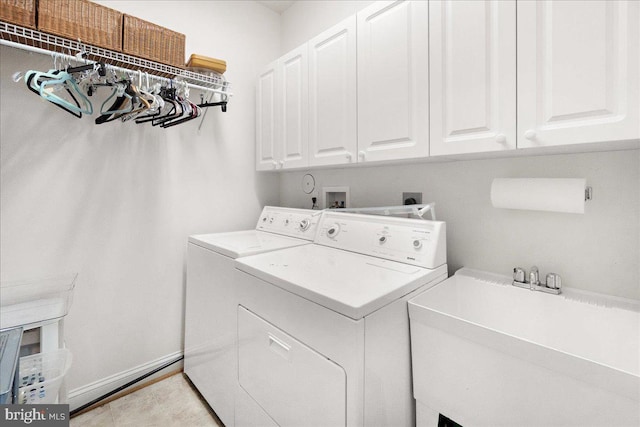 clothes washing area featuring baseboards, cabinet space, independent washer and dryer, and a sink