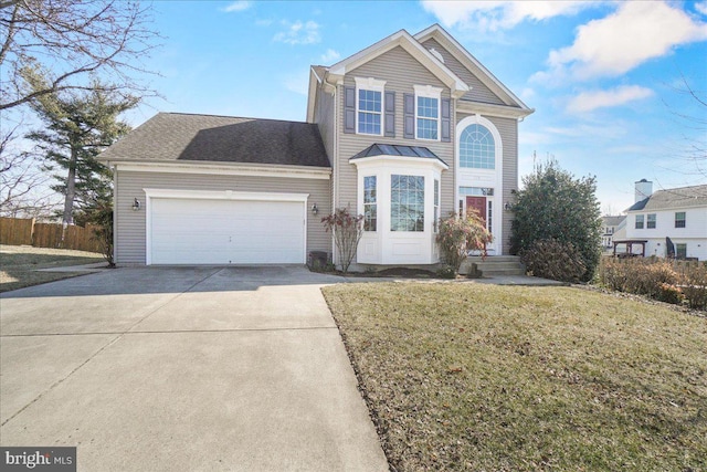 traditional-style home with a garage, driveway, and a front yard