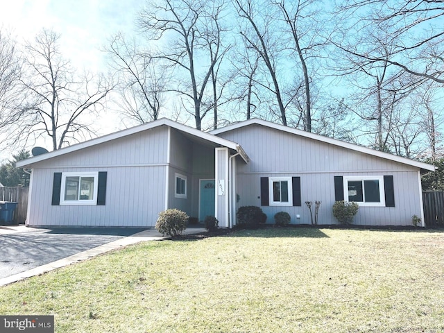 view of front of house with a front yard, fence, and driveway