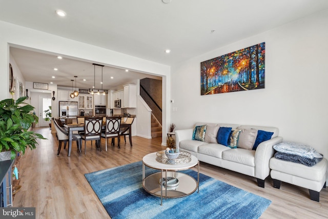 living room with light wood-style floors, recessed lighting, and stairs