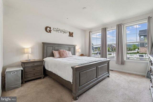 bedroom with baseboards and light carpet