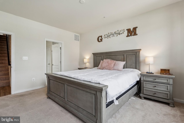 bedroom with baseboards, visible vents, and light colored carpet
