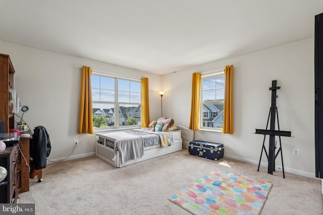 carpeted bedroom with multiple windows and baseboards