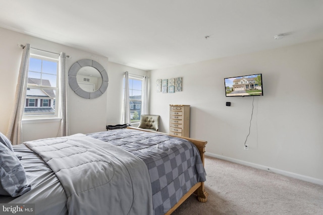carpeted bedroom featuring baseboards and multiple windows
