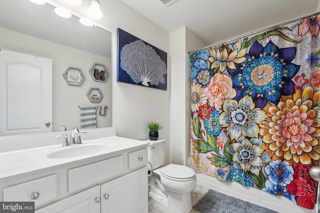 bathroom with toilet, vanity, and tile patterned flooring