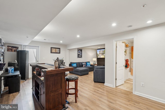 kitchen with a breakfast bar area, recessed lighting, and light wood-style floors