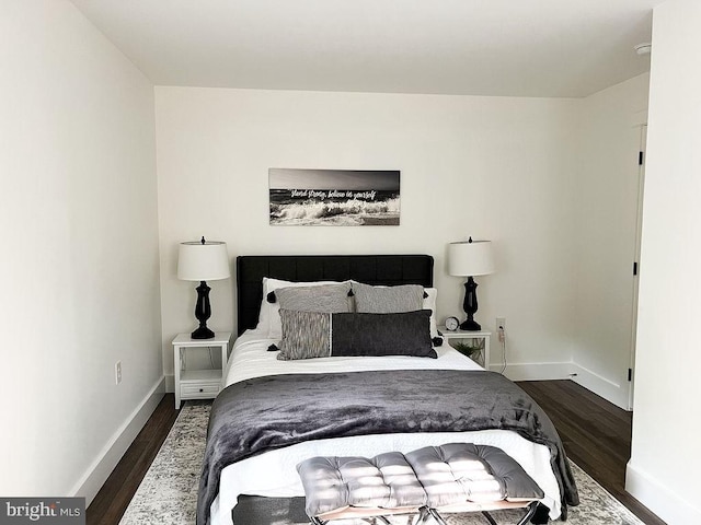 bedroom with baseboards and dark wood finished floors