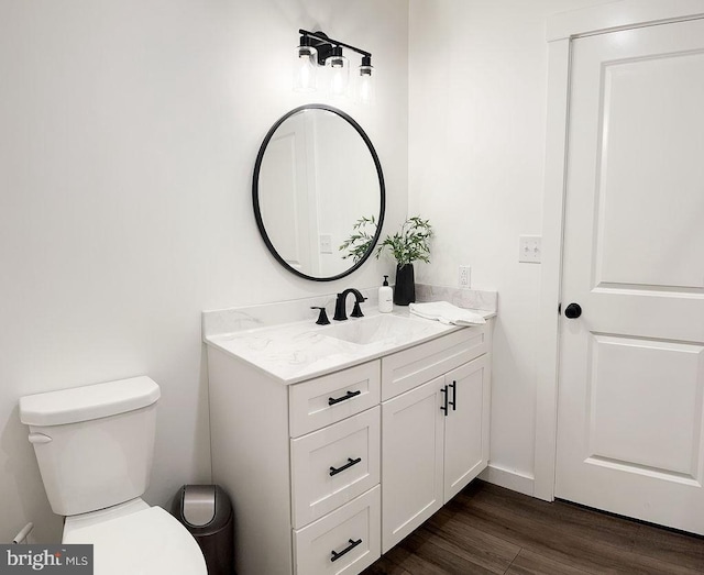 bathroom with toilet, wood finished floors, and vanity