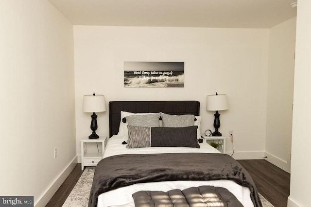 bedroom with baseboards and dark wood finished floors