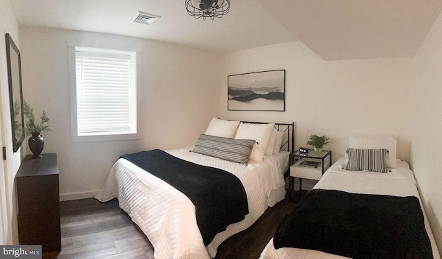 bedroom with dark wood-style flooring, visible vents, and baseboards