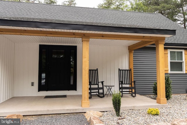 property entrance with covered porch and roof with shingles