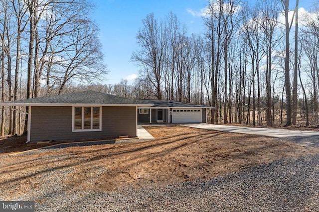 view of front of home featuring concrete driveway, roof with shingles, and an attached garage