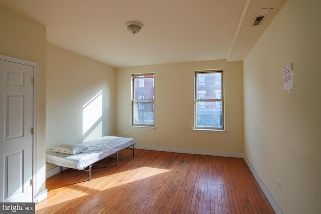 unfurnished room with visible vents, light wood-style flooring, and baseboards