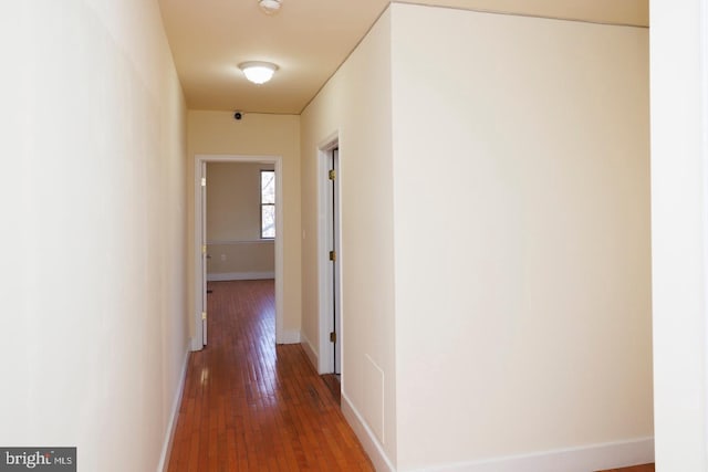 hallway with dark wood-style floors and baseboards