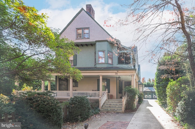 victorian home featuring a garage, a chimney, and a porch