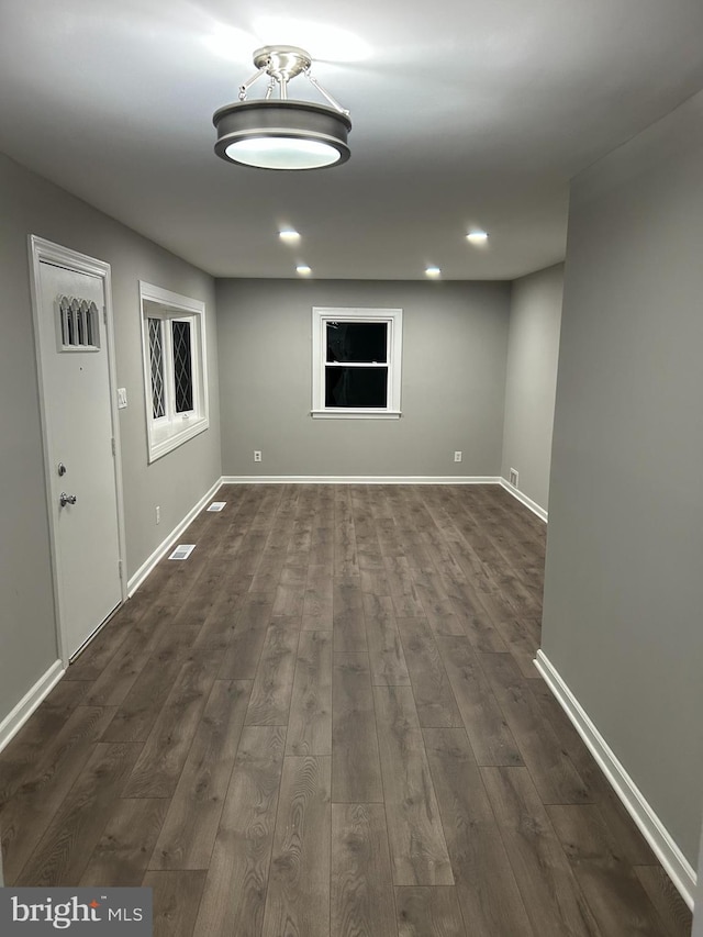 empty room with recessed lighting, visible vents, baseboards, and dark wood finished floors