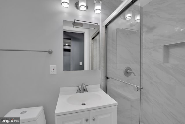 full bathroom with a stall shower, vanity, and toilet