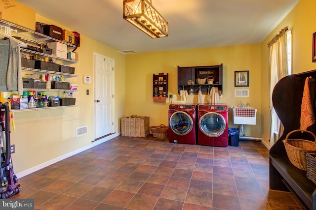 laundry area featuring laundry area, washing machine and dryer, visible vents, and baseboards