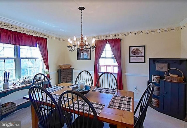 dining space featuring a wainscoted wall, ornamental molding, and a notable chandelier