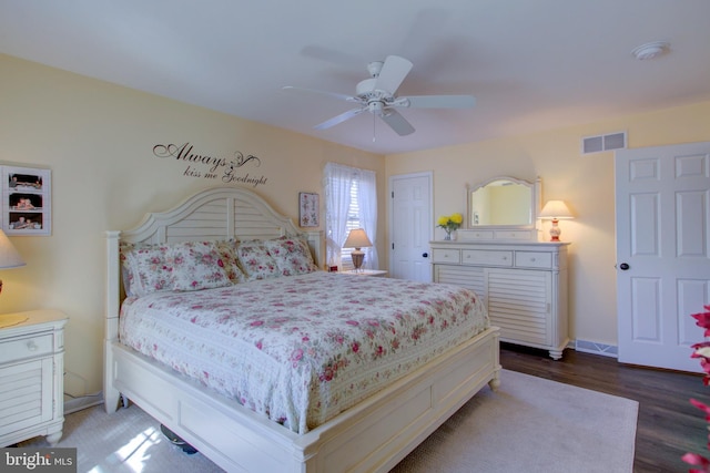 bedroom with baseboards, wood finished floors, visible vents, and a ceiling fan