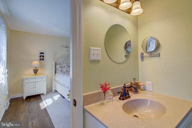 bathroom featuring wood finished floors, vanity, and baseboards