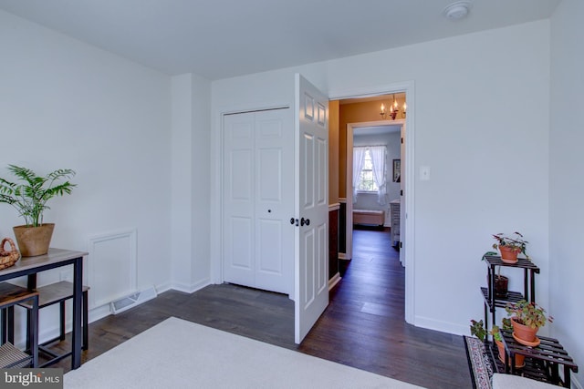 interior space with a chandelier, dark wood finished floors, visible vents, and baseboards