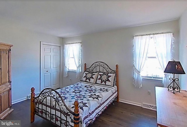 bedroom featuring a closet, visible vents, dark wood finished floors, and baseboards