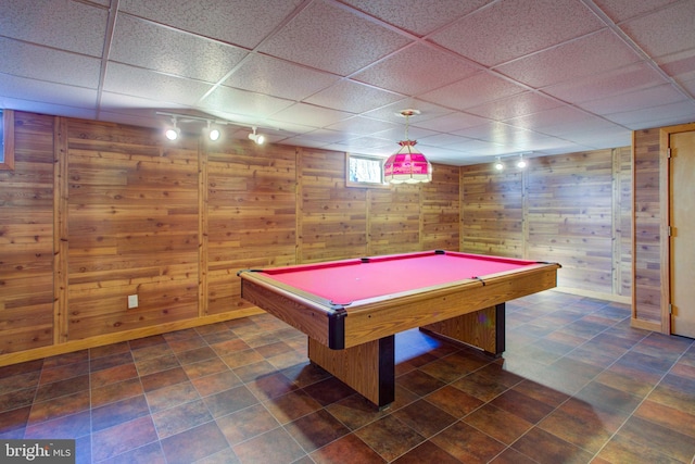 playroom with baseboards, wood walls, a paneled ceiling, and track lighting