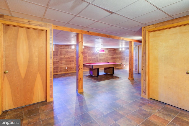 playroom featuring a drop ceiling and wood walls