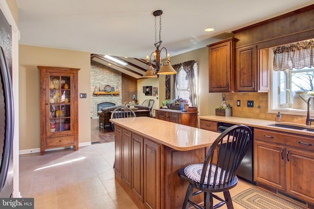 kitchen with dishwashing machine, a kitchen island, a sink, vaulted ceiling, and backsplash