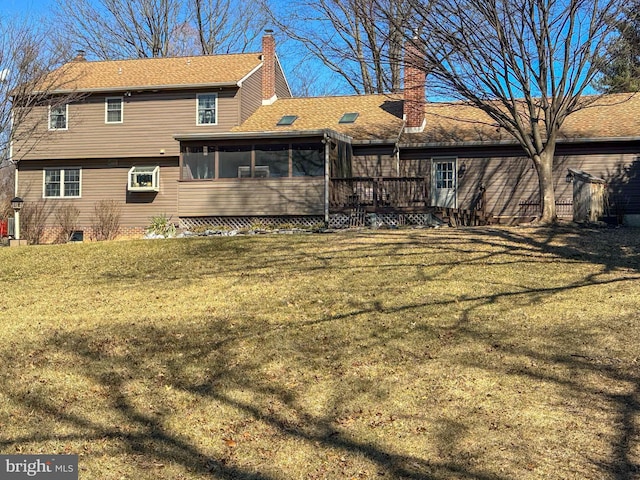 back of property with a lawn, a chimney, and a sunroom