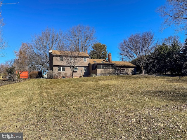 back of property featuring a yard and a chimney